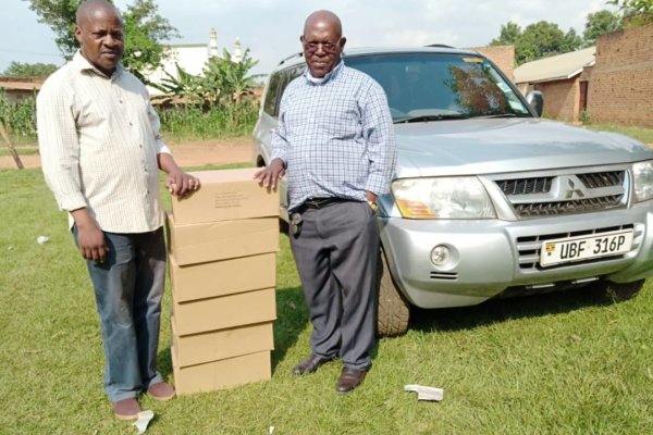Bro Hannington Balita receiving Bibles from Bro Stephen Ibale for further distribution